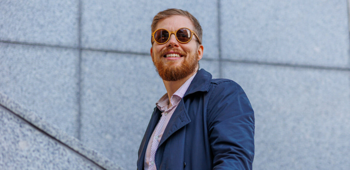 A man walks up the stairs, smiling as he looks upward.