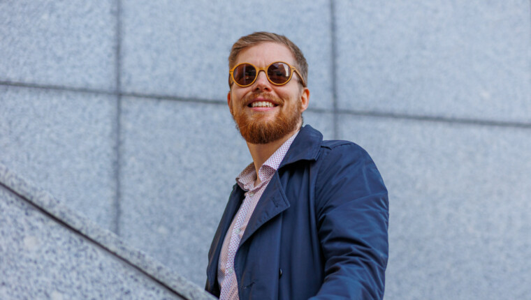 A man walks up the stairs, smiling as he looks upward.